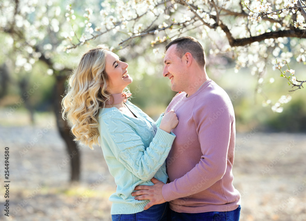 Fototapeta premium Beautiful couple in the flowering gardens in the spring
