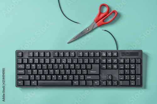 Red scissors and a keyboard with a cut wire. Idea and concept for the topic of censorship or freedom of the press. photo