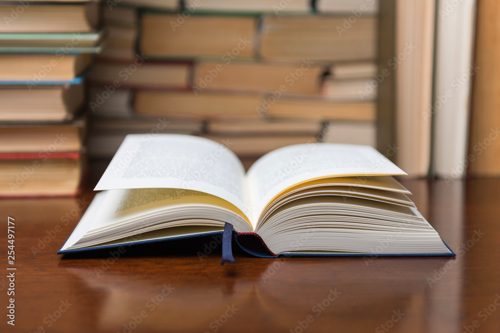 open book on the table, on the background of many books open book on the table, on the background of many books