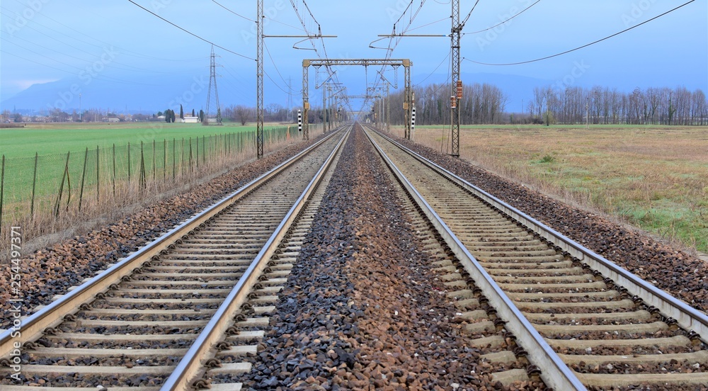 railway in the field two strips of rail and wires above them