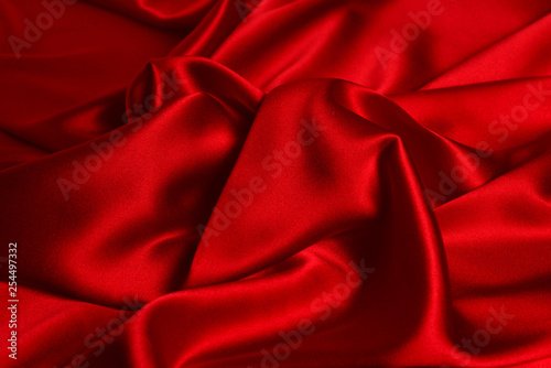 Red silk or satin luxury fabric texture can use as abstract background. Top view.