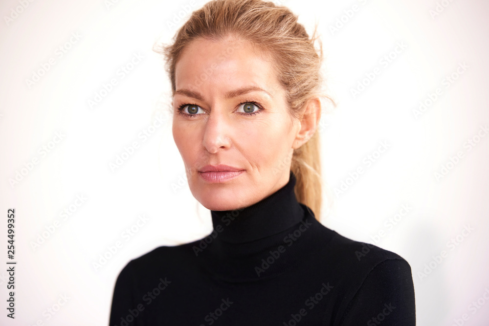 Fototapeta premium Portrait shot of attractive middle aged woman looking thoughtfully while standing at isolated white background