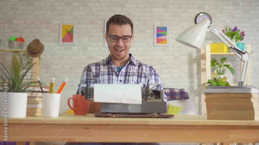 Portrait of a young man writer typing enthusiastically on an old typewriter Portrait of a young man writer typing enthusiastically on an old typewriter