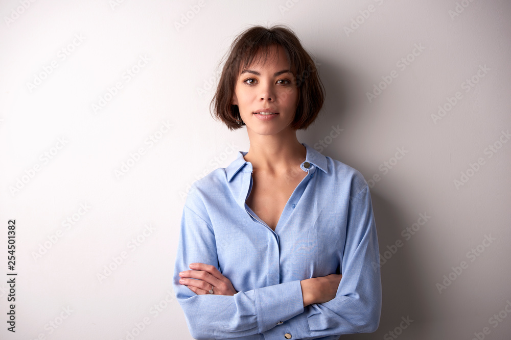 Attractive businesswoman with folded arms standing at isolated background Attractive businesswoman with folded arms standing at isolated background