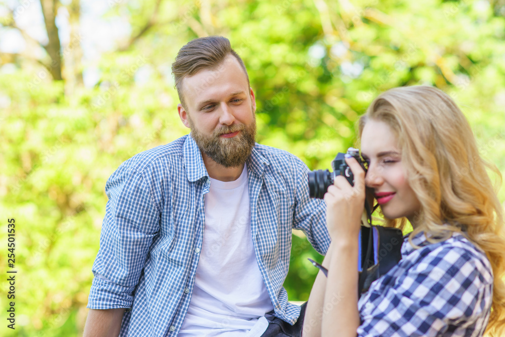 Man and woman having date outdoor. Girl wit a photo camera and her boyfriend. Man and woman having date outdoor. Girl wit a photo camera and her boyfriend.