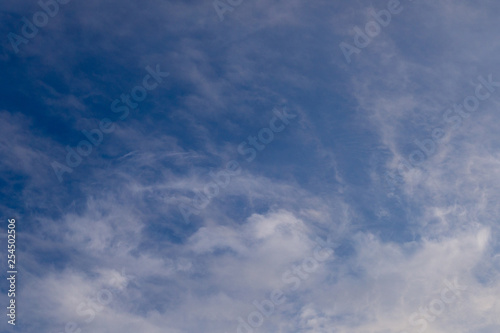 Blue sky with clouds and sun reflection in water with place for your text. blue sky background with white clouds