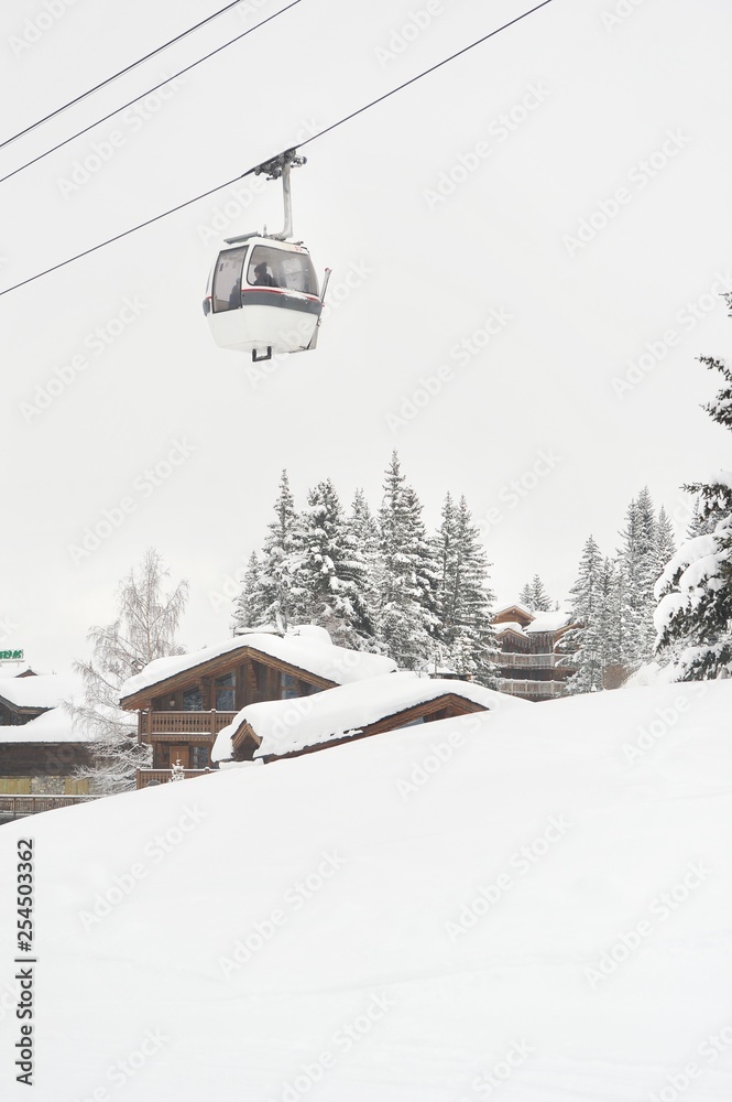 Winter scenery of a ski resort with gondola and chalets Winter scenery of a ski resort with gondola and chalets
