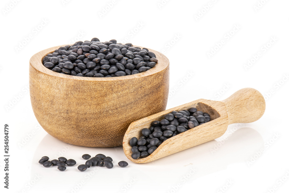 Lot of whole black lentils beluga variety with wooden bowl isolated on white background Lot of whole black lentils beluga variety with wooden bowl isolated on white background