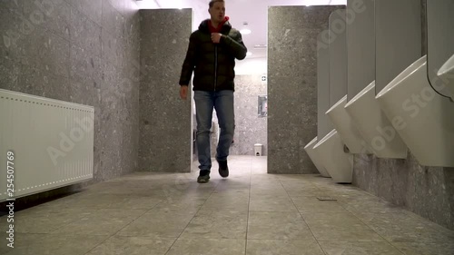 A man going to a public toilet to urinate and then washing his hands photo