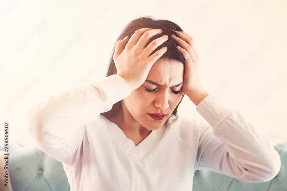 Young woman suffering from strong headache or migraine sitting at home, millennial guy feeling intoxication and pain touching aching head, morning after hangover concept Young woman suffering from strong headache or migraine sitting at home, millennial guy feeling intoxication and pain touching aching head, morning after hangover concept