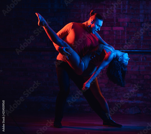 Professional dancers perform an incendiary dance in a dark room with illumination photo