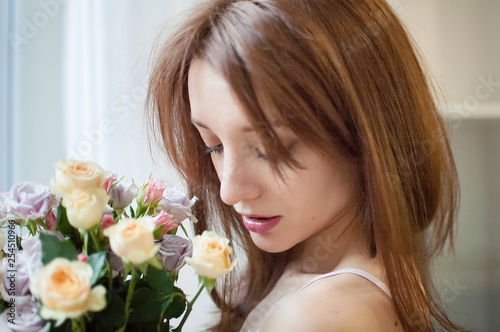 Close up of young female teen with flowers near the window at home