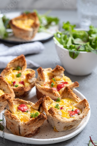 Egg muffins with peppers in a toast cup for breakfast brunch.