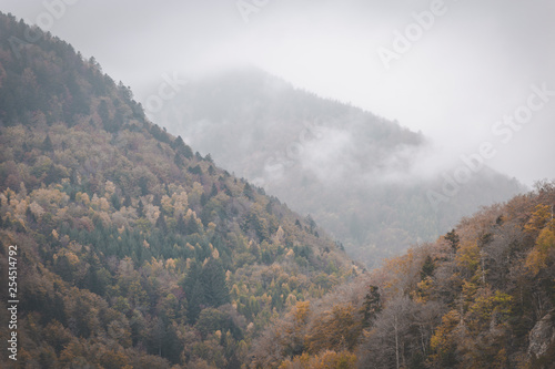 Clouds rolling through autumn mountains on dark and moody day. Vosges  France