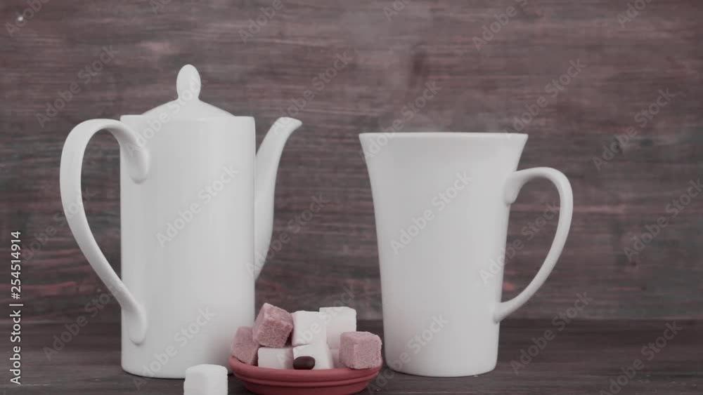Coffee drink - coffee pot and cup of steaming coffee with sugar cubes on wooden table. Wooden background. Coffee drink - coffee pot and cup of steaming coffee with sugar cubes on wooden table. Wooden background.