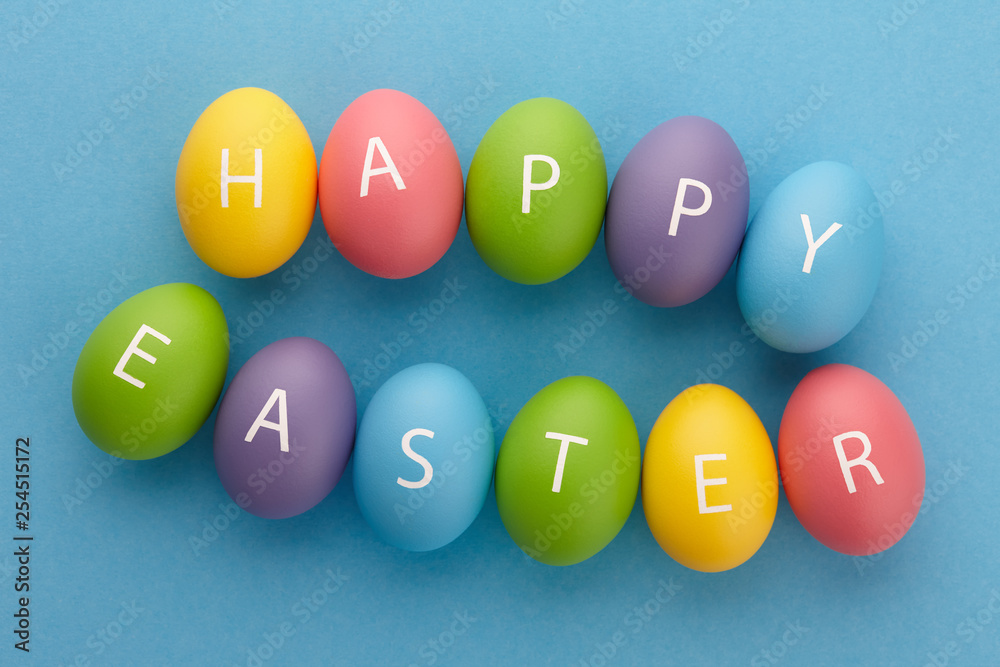 Painted eggs arranged in Happy Easter greeting on blue background Painted eggs arranged in Happy Easter greeting on blue background