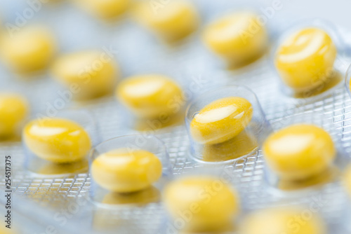 Medicine yellow pills packed in blisters. Macro. Copy space for text