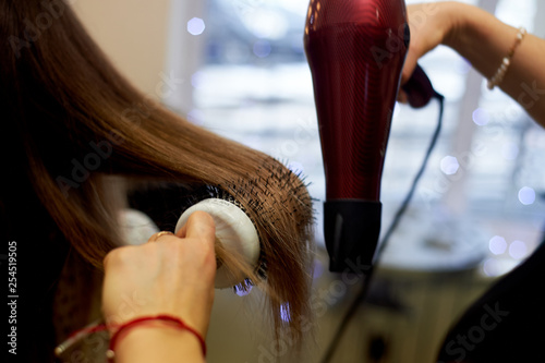 Hair styling a round brush. Drying and laying on a round comb.
