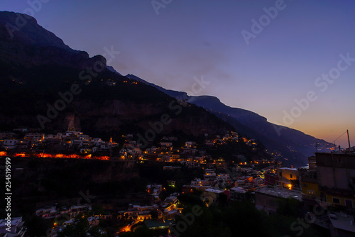 View on a city in mountains near coast. Town at the sea at dusk or night © lookproduction