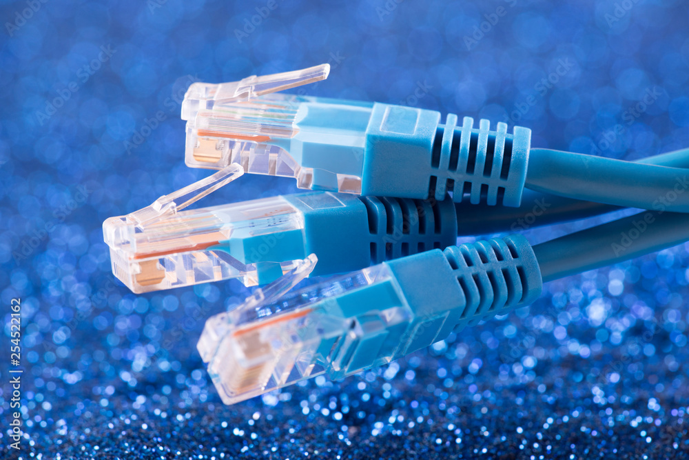 Three network cables over blue sparkles background 