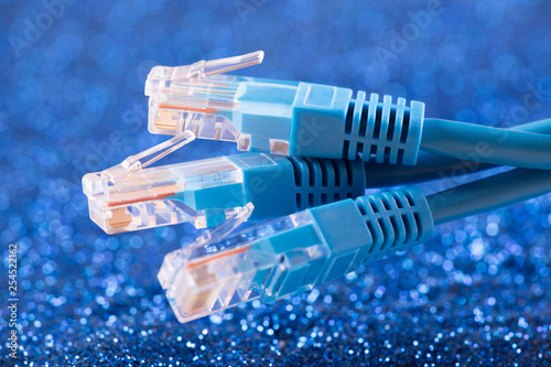 Three network cables over blue sparkles background 