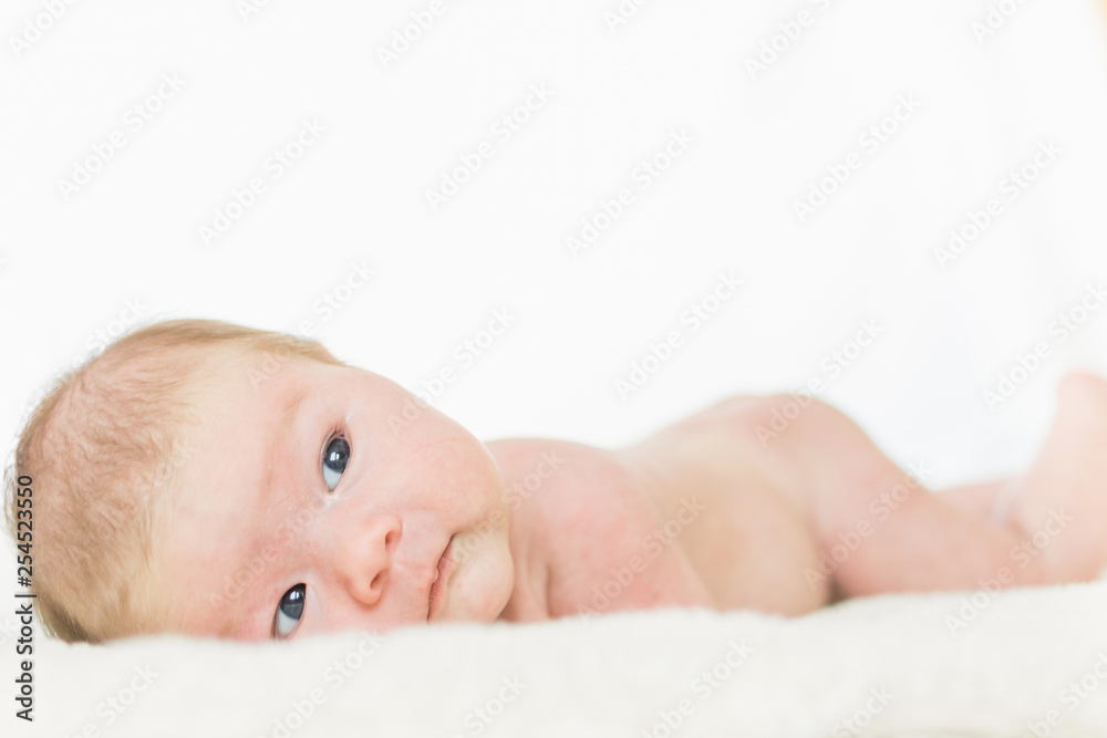 Infant baby portrait in white look at camera Infant baby portrait in white look at camera