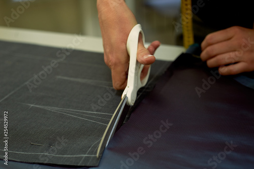 Master cuts fabric. Nesting. Suiting fabric marked with white chalk. Cutting and sewing