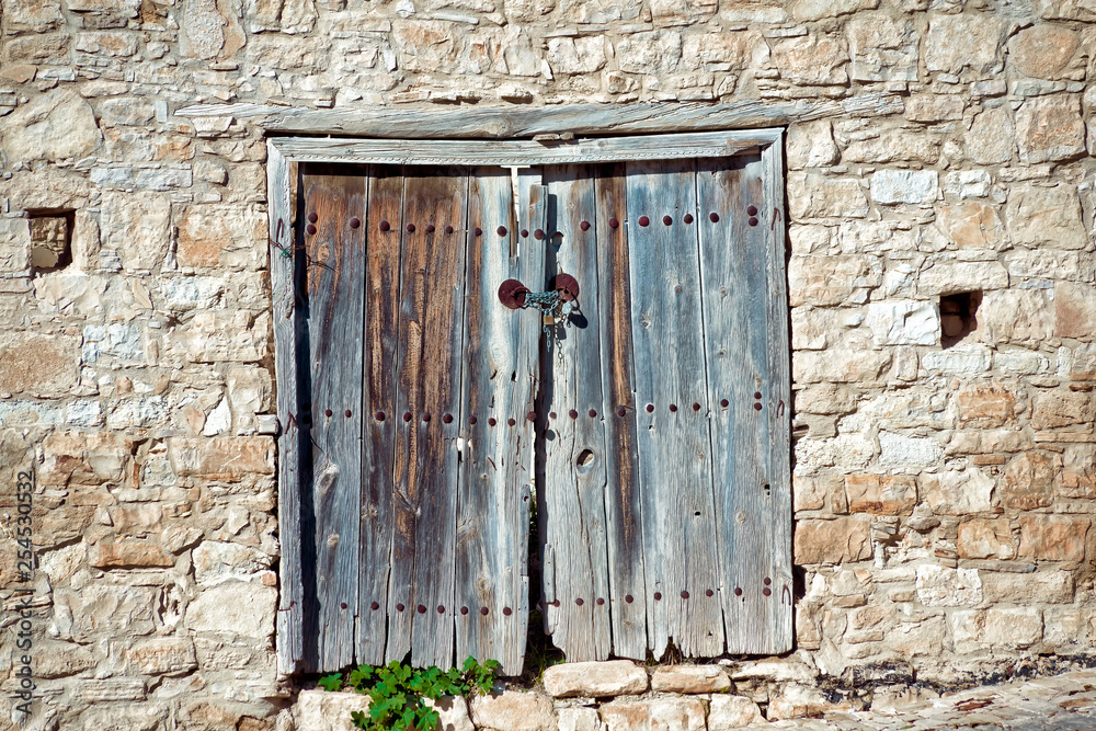 Old weathered door in a stone wall. Cyprus