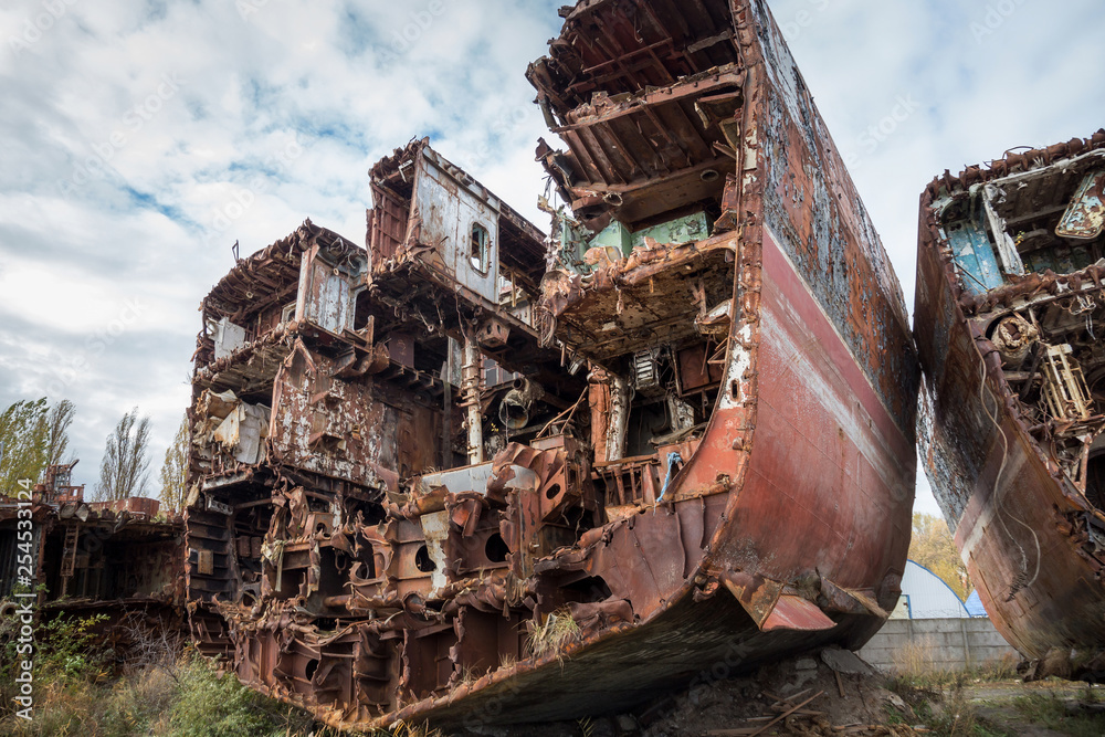 Huge rusty pieces of decommissioned marine ship that was cut and left on the shore.
