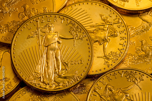 Pile of golden coins with Liberty on US Treasury issue Gold Eagle one ounce pure gold coin