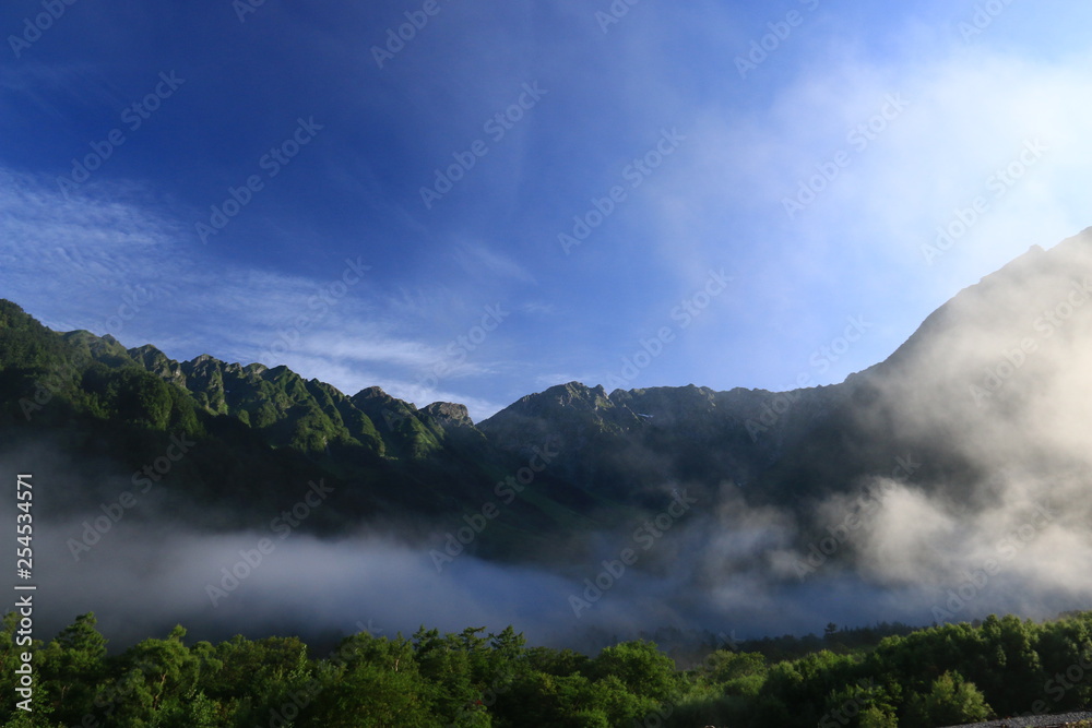 北アルプス　神々しい上高地の朝の風景　雲と岳沢と穂高連峰と