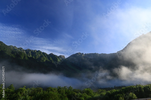 北アルプス 神々しい上高地の朝の風景 雲と岳沢と穂高連峰と