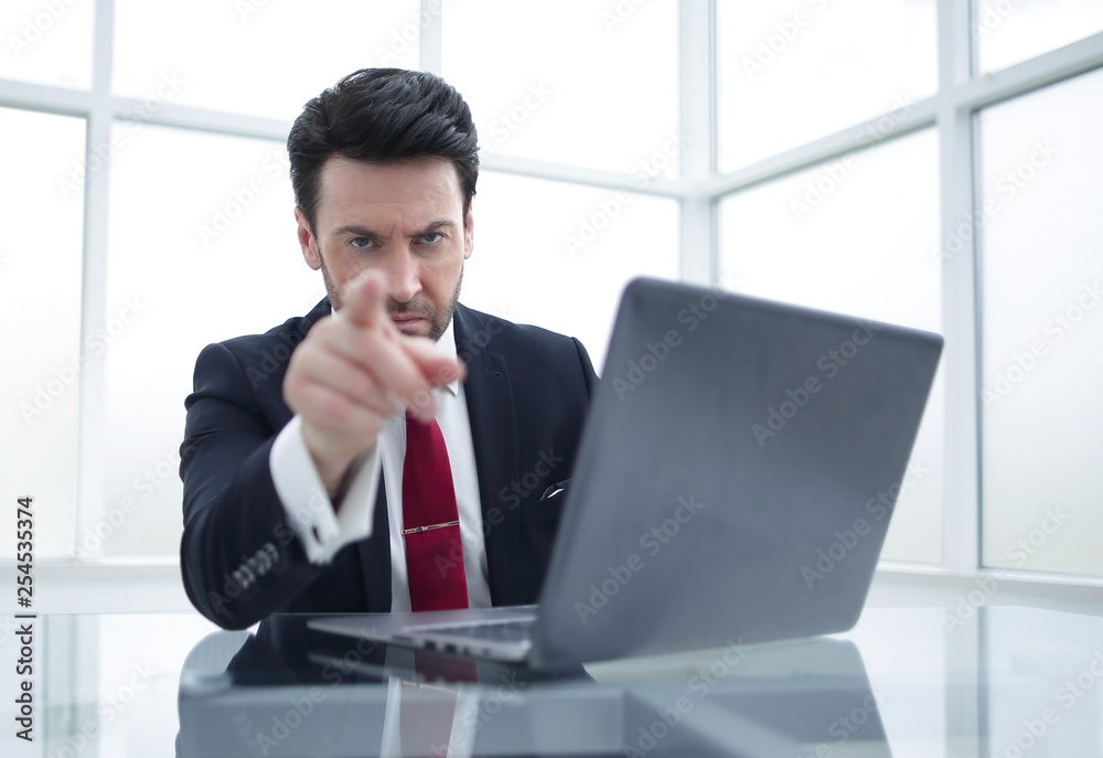 serious Businessman pointing the finger at you,sitting at his Desk serious Businessman pointing the finger at you,sitting at his Desk