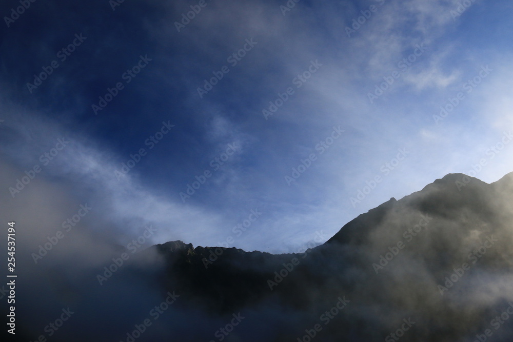 北アルプス　神々しい上高地の朝の風景　雲に煙る穂高連峰と明神岳