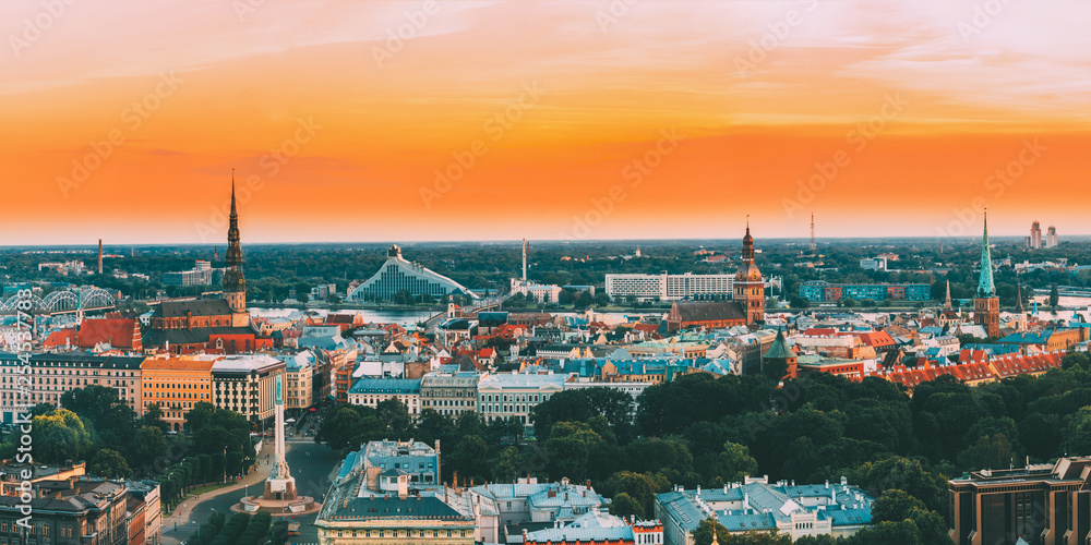 Riga, Latvia. Top View Panorama Skyline Cityscape At Sunset Light. St. Peter's Church, Boulevard Of Freedom, National Library, Dome Cathedral, Basilica Of St. James