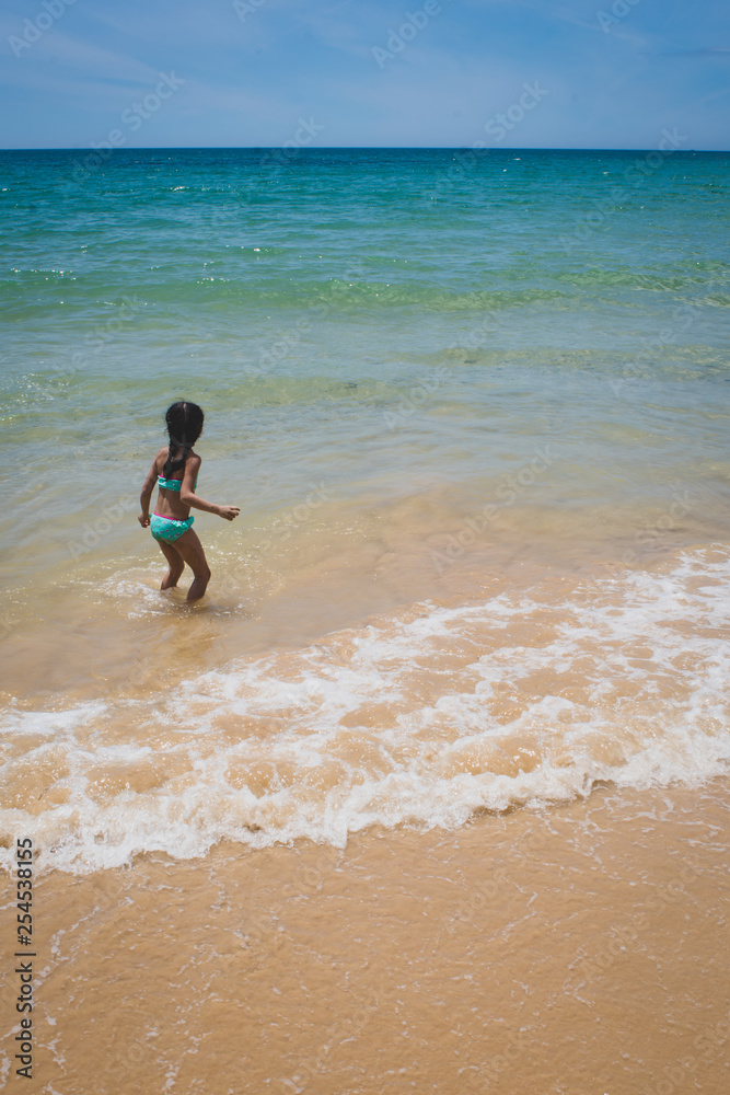 Girl walking on a tropical beach - blue skies and sunny day. Girl walking on a tropical beach - blue skies and sunny day.