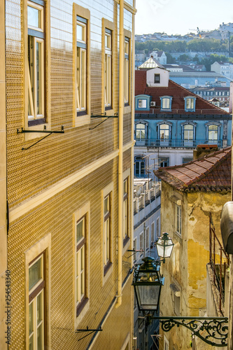 Narrow streets of the castle district with the facades of the houses decorated with tiles in Lisbon, Portugal