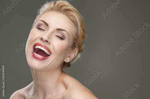 Bringing happiness. Closeup portrait of a gorgeous happy woman laughing cheerfully with her eyes closed