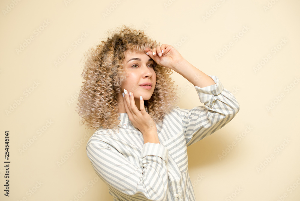 Blondegirl with curly hair . Beautiful model woman with wavy hairstyle.