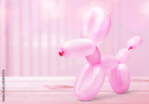 Pink balloon in form of dog on background
