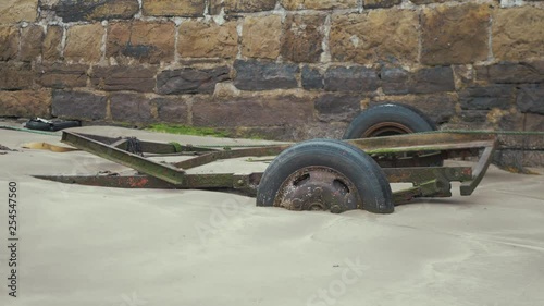 Boat trailer sunk in sand at harbor beach photo