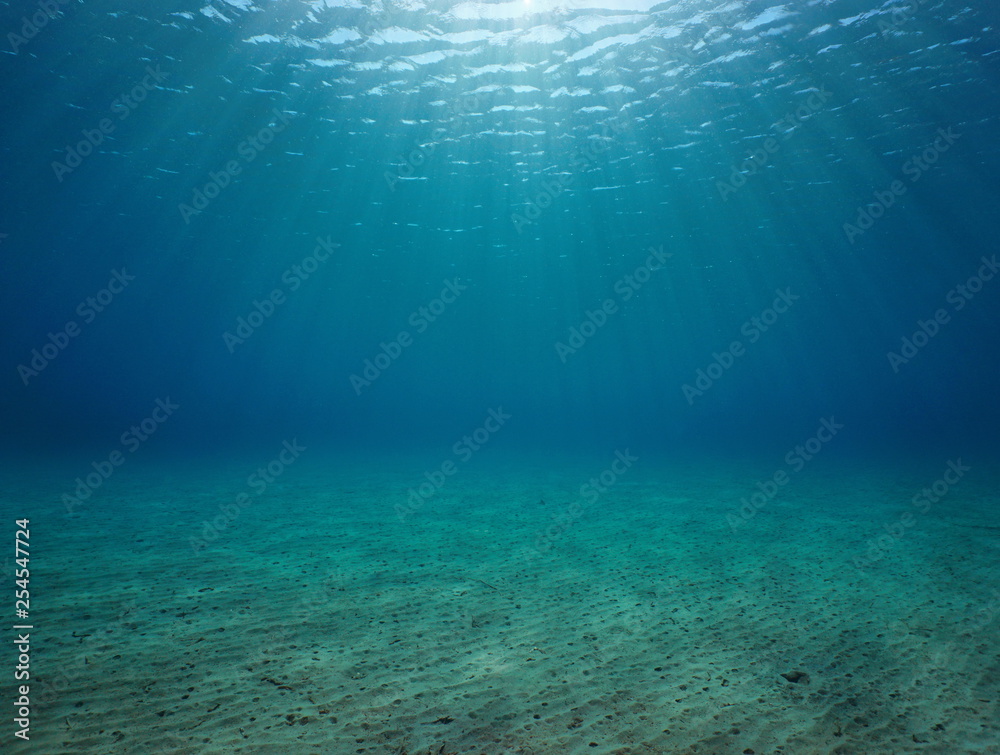 Underwater seascape sandy seabed with natural sunlight below water surface in the Mediterranean sea, France