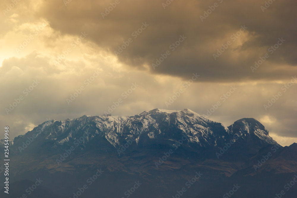 photo of the iztaccihuatl volcano covered by snow, with a dramatic sky