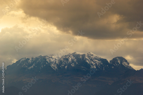 photo of the iztaccihuatl volcano covered by snow, with a dramatic sky photo