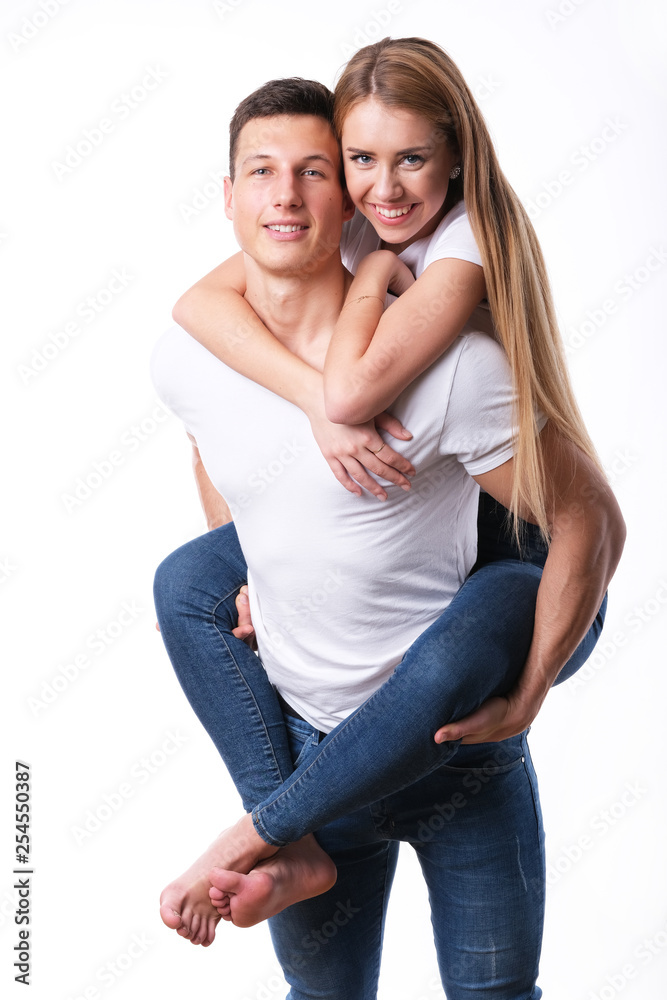 Handsome man piggybacking his girlfriend on white Handsome man piggybacking his girlfriend on white