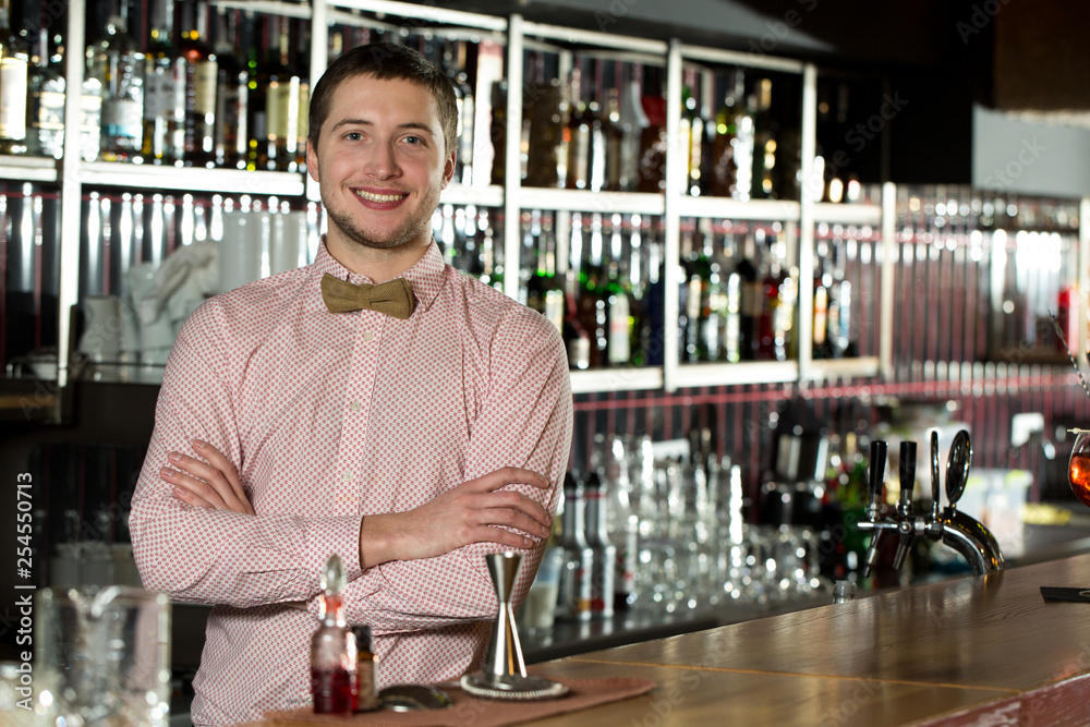 Engaging others. Well-dressed bartender smiling and ready to take orders.