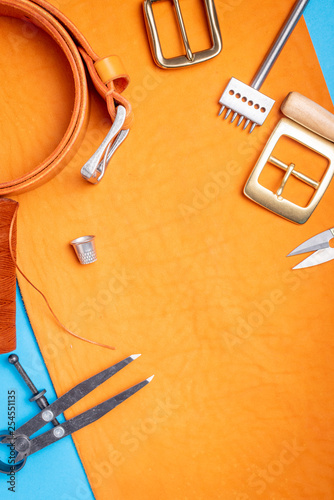 Close up of a tanner or tailor workplace with orange tanned leather. Handmade workshop background