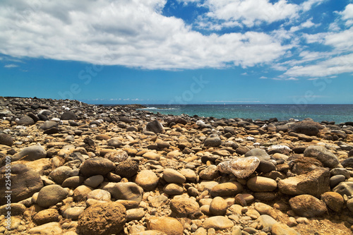 Black stonesl beach under blue sky