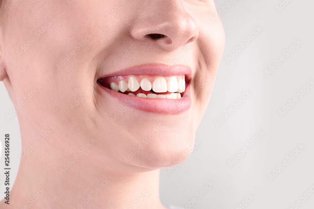 Obraz premium Young woman with healthy teeth smiling on white background, closeup