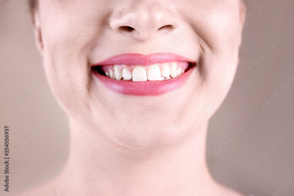 Obraz premium Young woman with healthy teeth smiling on color background, closeup